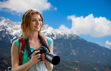 Image showing woman with backpack and camera over alps mountains