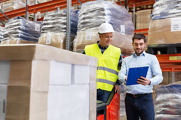 Image showing businessman and loader in forklift at warehouse