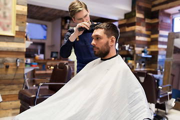 Image showing man and barber cutting hair at barbershop