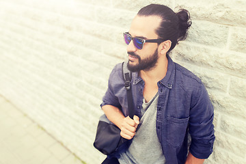 Image showing man with backpack standing at city street wall