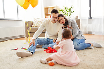 Image showing baby girl with birthday gift and parents at home