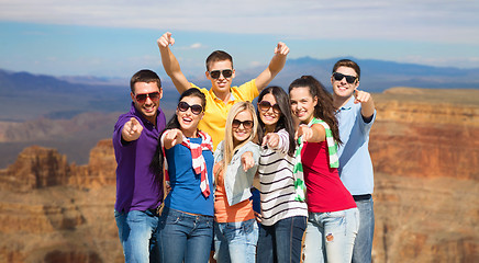 Image showing happy friends pointing at you over grand canyon