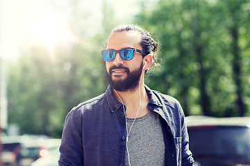 Image showing man with earphones listening to music in city