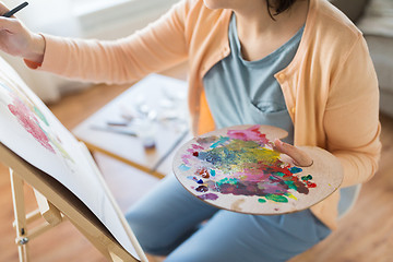 Image showing artist with palette painting at art studio