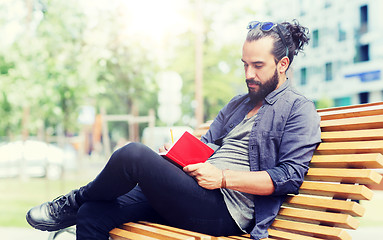 Image showing man with notebook or diary writing on city street