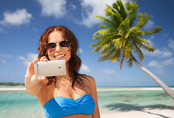 Image showing woman taking selfie by smartphone on beach