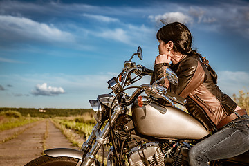 Image showing Biker girl sitting on motorcycle