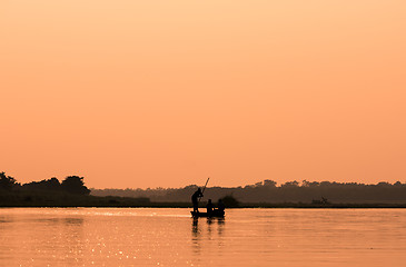 Image showing Men in a boat on a river silhouette