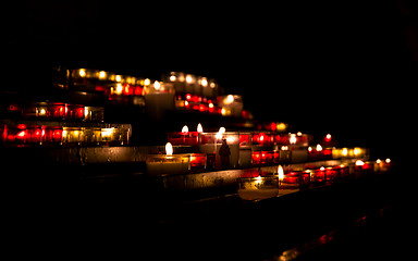 Image showing Bright lights of burning candles in the darkness of the church