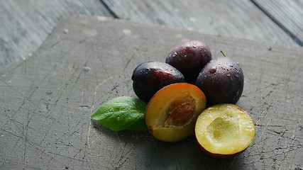 Image showing Ripe plumbs on cutting board 