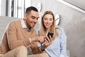 Image showing man and woman with smartphone at office stairs