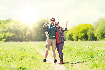 Image showing happy couple with backpacks hiking outdoors