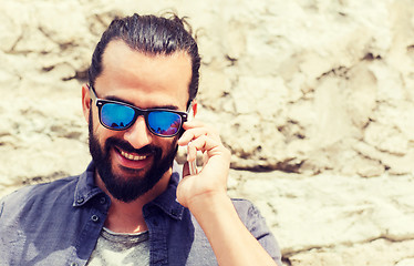 Image showing smiling man with smartphone calling on city street