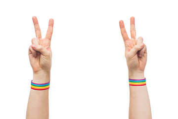 Image showing hands with gay pride rainbow wristbands make peace