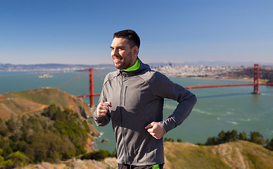 Image showing happy young man running over golden gate bridge