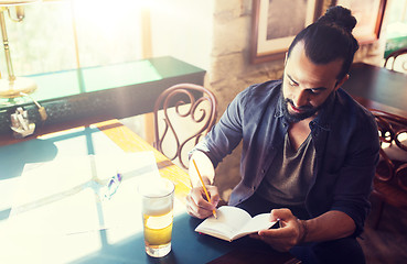 Image showing man with beer writing to notebook at bar or pub