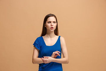 Image showing Let me think. Doubtful pensive woman with thoughtful expression making choice against pastel background