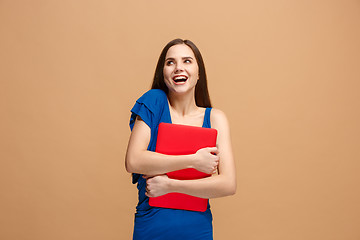 Image showing Businesswoman hugging laptop on pastel studio