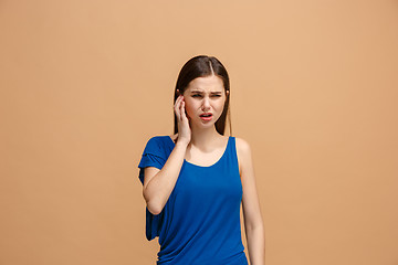 Image showing The Ear ache. The sad woman with headache or pain on a pastel studio background.