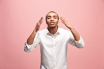 Image showing Beautiful male half-length portrait isolated on pink studio backgroud. The young emotional surprised man