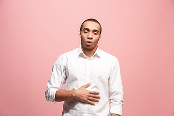 Image showing The happy business man standing and smiling against pink background.