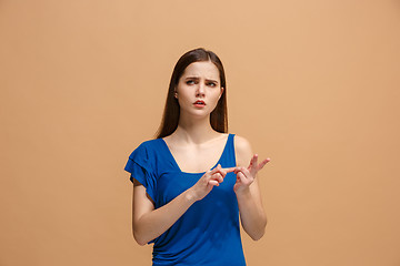 Image showing Let me think. Doubtful pensive woman with thoughtful expression making choice against pastel background