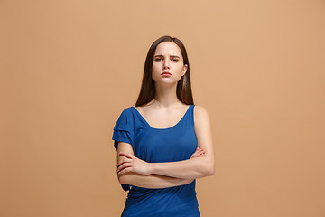Image showing The serious woman standing and looking at camera against pastel background.