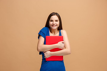 Image showing Businesswoman hugging laptop on pastel studio