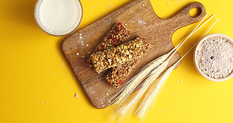 Image showing Cereal bars and oats on wooden board