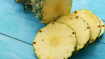 Image showing Slices of pineapple on blue wood