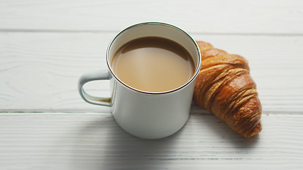 Image showing Cup of coffee and baked croissant