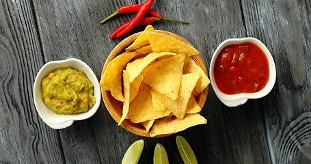 Image showing Served nachos with sauces on table