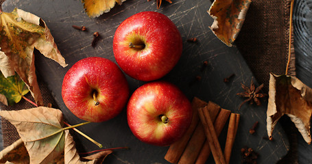 Image showing Ripe apples and cinnamon sticks