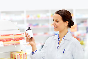 Image showing happy female apothecary with drug at pharmacy