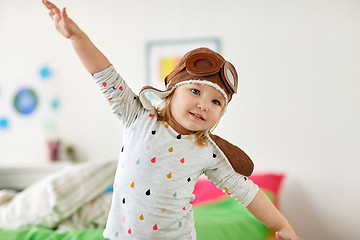 Image showing happy little girl in pilot hat playing at home