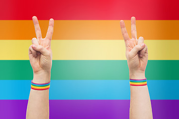 Image showing hands with gay pride rainbow wristbands make peace