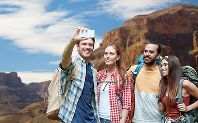 Image showing friends with backpack taking selfie by smartphone