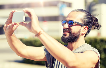 Image showing man taking video or selfie by smartphone in city