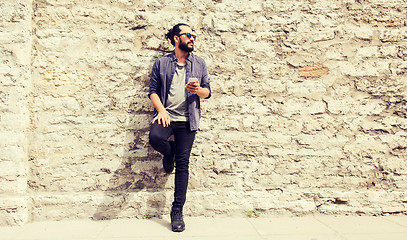 Image showing man with smartphone at stone wall on city street