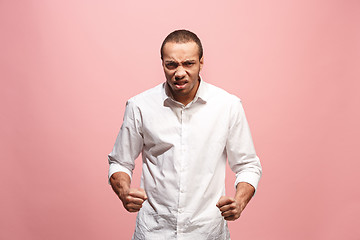 Image showing The young emotional angry man screaming on pink studio background