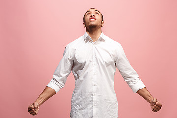 Image showing The young emotional angry man screaming on pink studio background