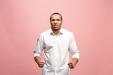 Image showing The young emotional angry man screaming on pink studio background