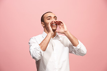 Image showing Isolated on pink young casual man shouting at studio