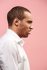 Image showing The young emotional angry man screaming on pink studio background