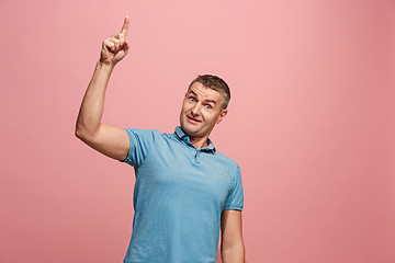 Image showing The young attractive man looking suprised isolated on pink