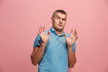 Image showing Portrait of the scared man on pink