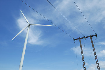 Image showing a windturbine close to a electric pylon