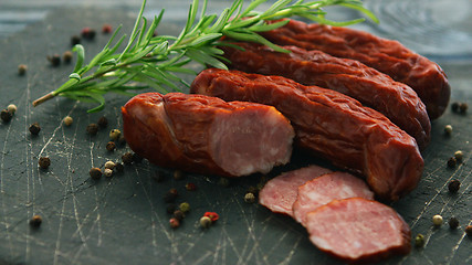 Image showing Smoked sausage and spices on board