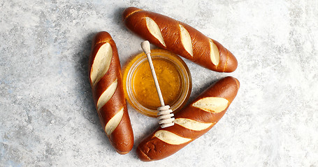 Image showing Three loafs with bowl of honey in middle