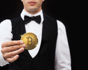 Image showing close up of casino dealer holding bitcoin 